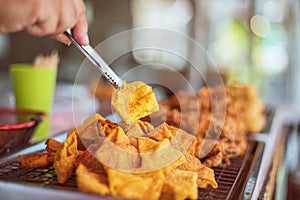 Hand of the merchant grabs the food tongs