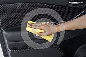 Hand with microfiber cloth cleaning interior car door