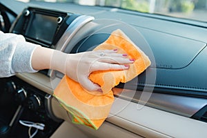 Hand with microfiber cloth cleaning seat, auto detailing and valeting concept, washing car care interior, selective focus