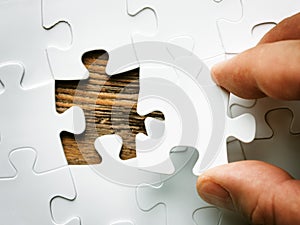 Hand with missing jigsaw puzzle piece. Business concept image for completing the final puzzle piece.