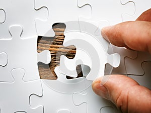 Hand with missing jigsaw puzzle piece. Business concept image for completing the final puzzle piece.