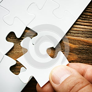 Hand with missing jigsaw puzzle piece. Business concept image for completing the final puzzle piece.