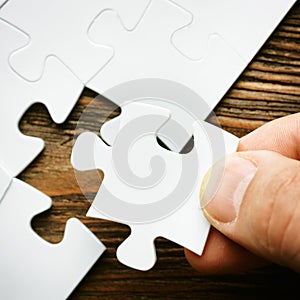 Hand with missing jigsaw puzzle piece. Business concept image for completing the final puzzle piece. photo