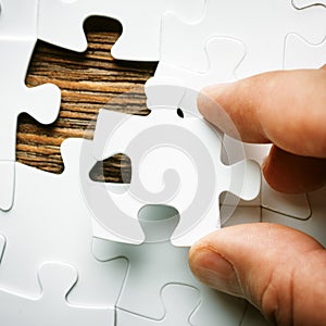 Hand with missing jigsaw puzzle piece. Business concept image for completing the final puzzle piece.