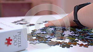 Hand mixes puzzle pieces, details of fascinating hobby for mental development