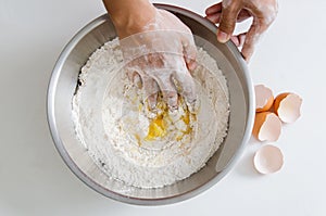 Hand mixing egg yolk,sugar and flour in a bowl