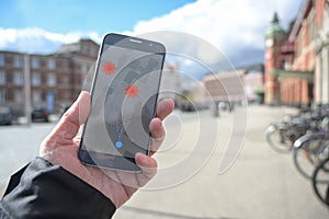 Hand with mobile phone and coronavirus tracking  app via bluetooth against the spread of the pandemic, but controversial when it