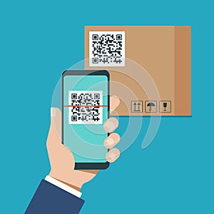 Hand with a modern smartphone scans qr code on a cardboard box