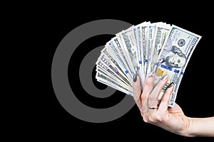 Hand with money isolated on black background. US Dollars in hand. Handful of money. Business woman offering money. Counting money.