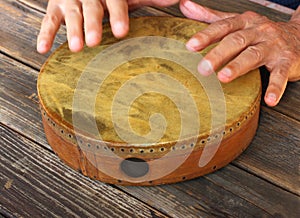 Hand in motion of senior man playing ethnic drum