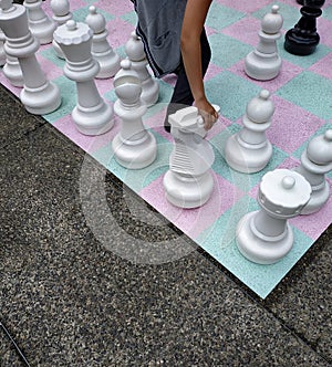 Hand moving knight on street chess board