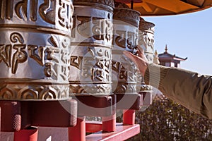 Hand moving tibetan buddhist prayer wheels.