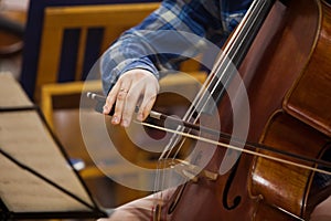 The hand of a musician playing the cello closeup