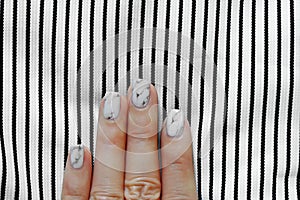 Hand and Nail Polish, Manicure Nail. Close Up Granite Gray Nails with Black and White Fabric Background