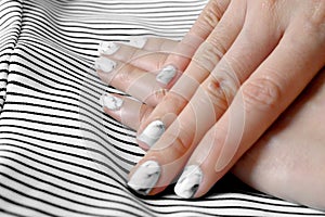 Hand and Nail Polish, Manicure Nail. Close Up Granite Gray Nails with Black and White Fabric Background