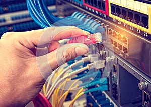 Hand with network cables connected to servers