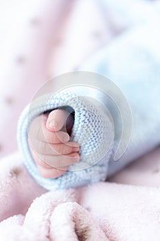 Hand of a newborn baby. Fingers of a newborn baby close up. Close-up lan hand of a newborn baby in a blue blouse not a