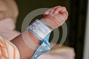 Hand of newborn baby with a name band on his wrist