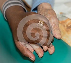 Hand of nurse holding a senior woman. Concept of helping hands, care for the elderly