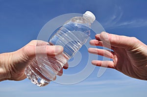 Hand Offering a Bottle of Water