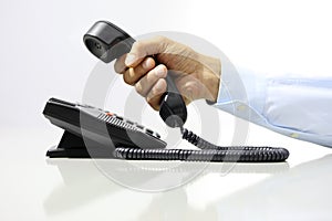 Hand with office phone on desk