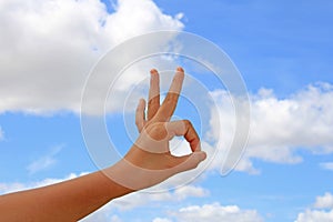 Hand with the ok sign with the blue sky in the background