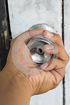 Hand on old door knobs
