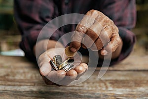 Hand old man begging for money because of the hunger on the wood table