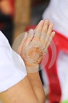 Hand of old people of asian pay respect to the Buddha and Thai m