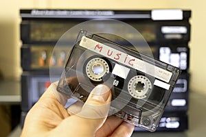 A hand with an old radio cassette tape