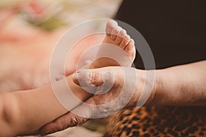 The hand of an old woman stroking the leg of a small child