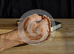 Hand of a older Muslim man fingering a rosary