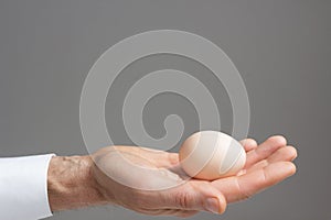 Hand with one hens egg.