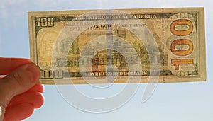 Hand with one hundred dollar banknote