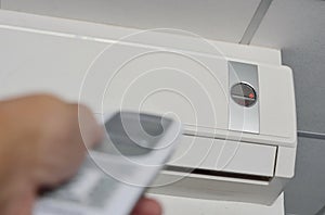 Hand open air conditioner on ceiling by remote control