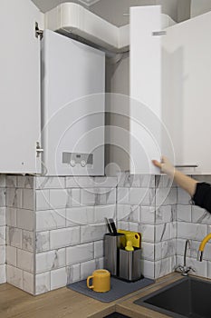 Hand open the gas boiler water heater installated in kitchen furniture