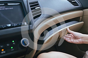 Hand open glove compartment box inside modern car