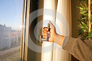 hand open gray plastic pvc window at home at early morning