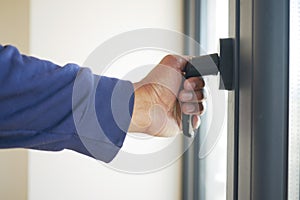 hand open gray plastic pvc window at home at early morning