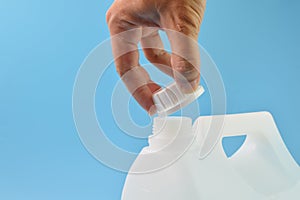 Hand opened white gallon bottle cap isolated on a blue background