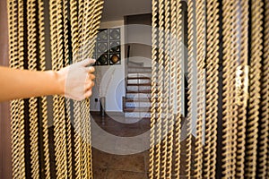 A hand opening a fly stopping door curtain