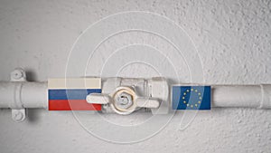 Hand opening a gas valve on a home pipeline symbolizing the end of energy cut-off from Russia to the European Union.