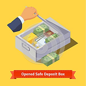 Hand opening a safe deposit box full of valuables