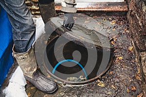 Hand opens sewer hatch in yard