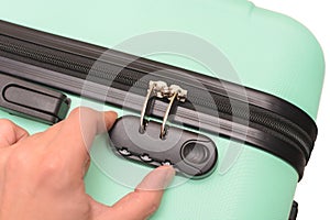 Hand opens suitcase combination lock on the suitcase.