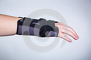 Hand in orthopedic orthosis on white backgroud