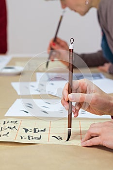 Hand with paint brush calligraphy