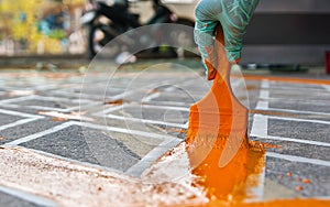 Hand with paint brush, painting road No parking yellow line area