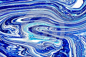 Hand painted background with mixed liquid blue, white, yellow paints. Abstract fluid acrylic painting. Applicable for
