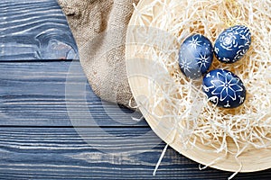 Hand painted dark blue easter eggs in nest and flowers